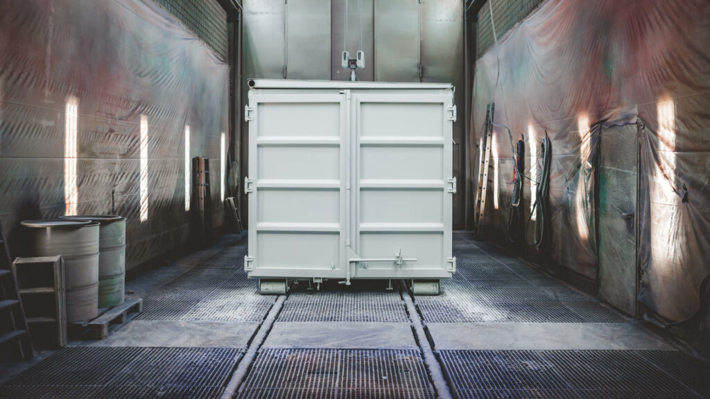 Frisch lackierter heller Container in der Lackierkabine der Laudon-Fertigung